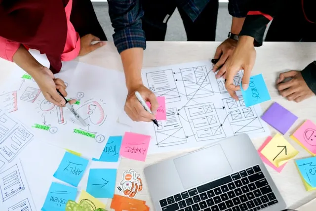 The team mapping out a product flow with wireframes and sticky notes